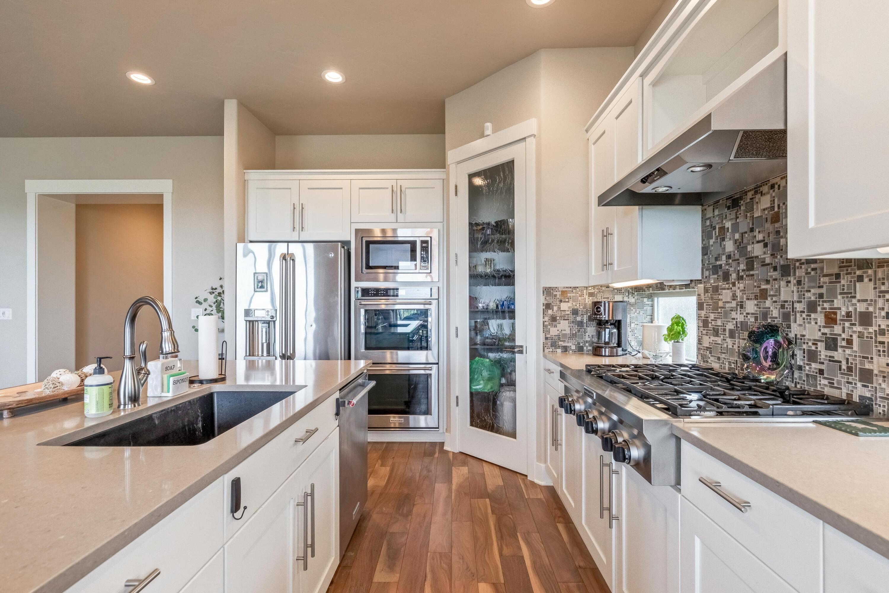 2375 Northwest Majestic Ridge Drive Bend, OR 97703 - Photo 7 of 28 a kitchen with stainless steel appliances a sink stove and cabinets