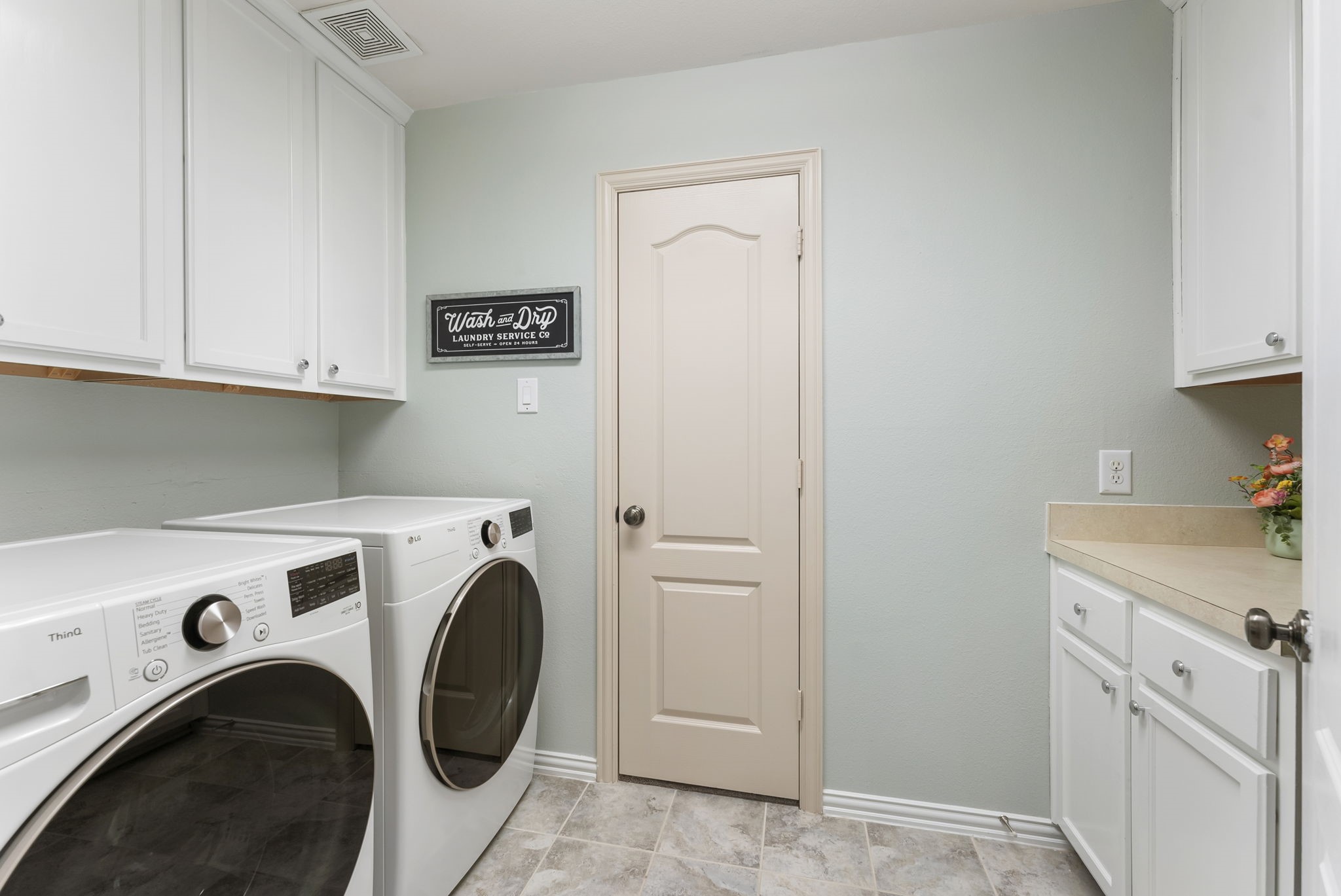 27515 Chris Ridge Court Spring, TX 77386 - Photo 17 of 31 Oversized laundry room with storage cabinets, and hanging rack. The best things is that the laundry room connects to the primary closet through that door.