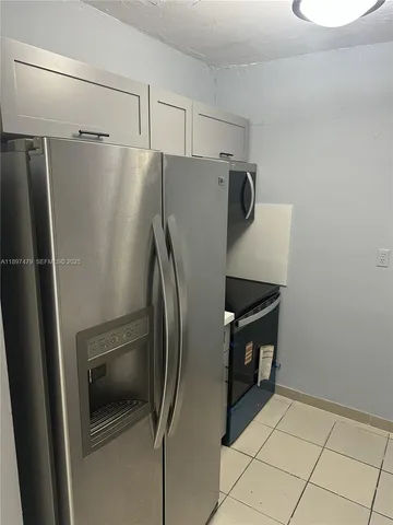 a metallic refrigerator freezer sitting in a kitchen