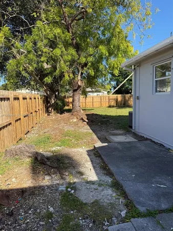a view of a yard with wooden fence