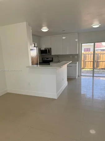 a large white kitchen with a large window