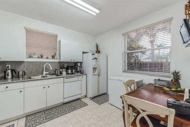 a kitchen with stainless steel appliances granite countertop a stove a sink a refrigerator a counter space and cabinets