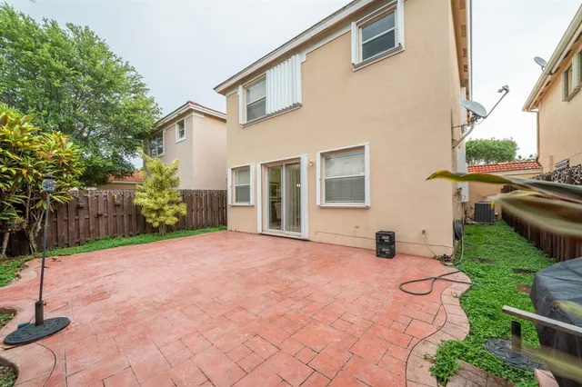 a view of a backyard with plants and brick wall