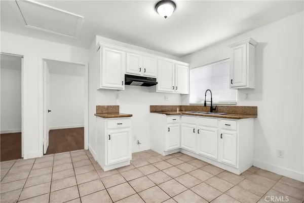 a kitchen with white cabinets appliances and a sink