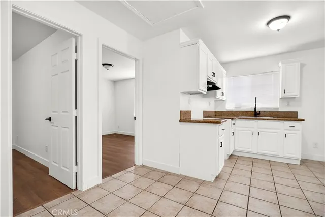 a kitchen with white cabinets and appliances