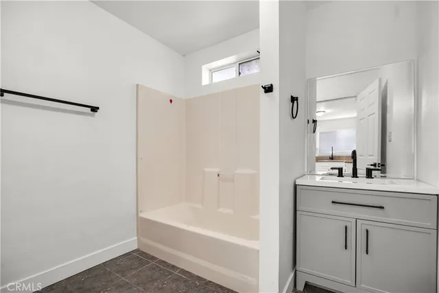 a bathroom with a bathtub sink vanity and mirror