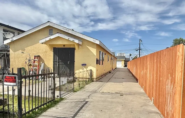 a view of a house with wooden fence