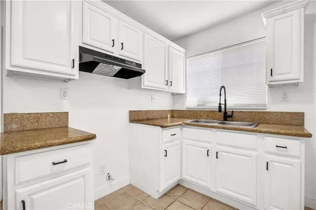 a kitchen with white cabinets and white appliances
