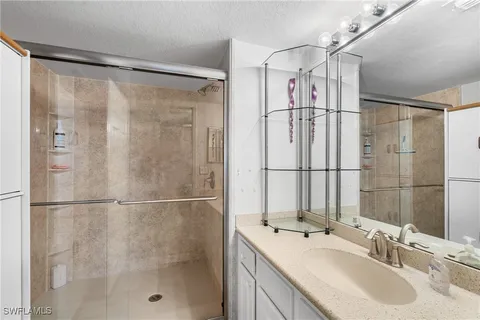 a bathroom with a shower sink and mirror