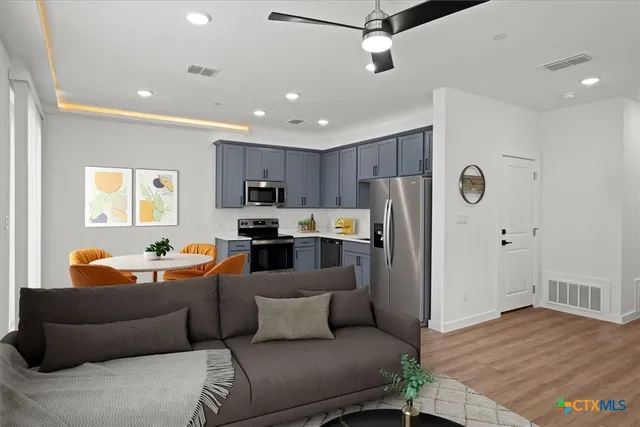 a living room with furniture and a wooden floor