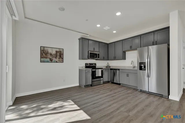 a kitchen with stainless steel appliances a refrigerator stove and sink