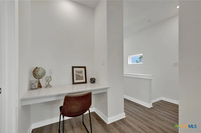 a view of workspace room with wooden floor ceiling fan and windows