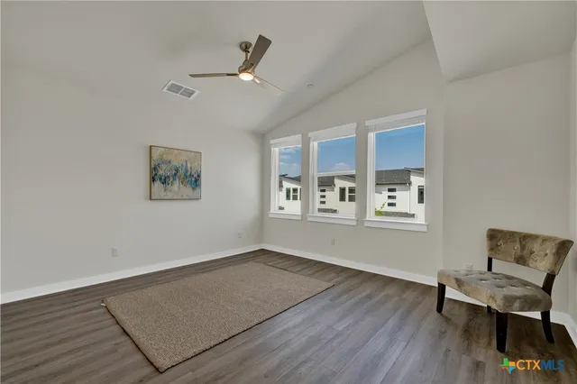a view of a livingroom with furniture an ceiling fan and wooden floor