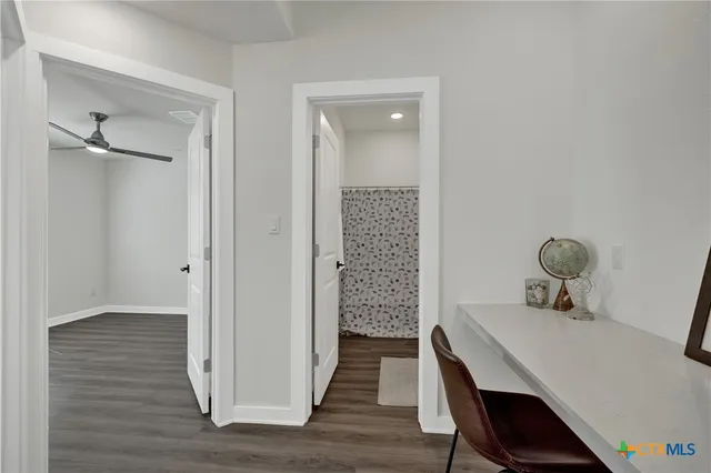 a bathroom with a granite countertop toilet a sink a mirror and a shower curtain