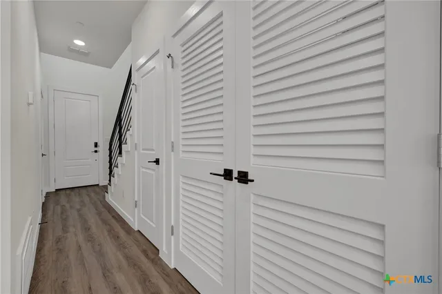 a view of a hallway with wooden floor and staircase