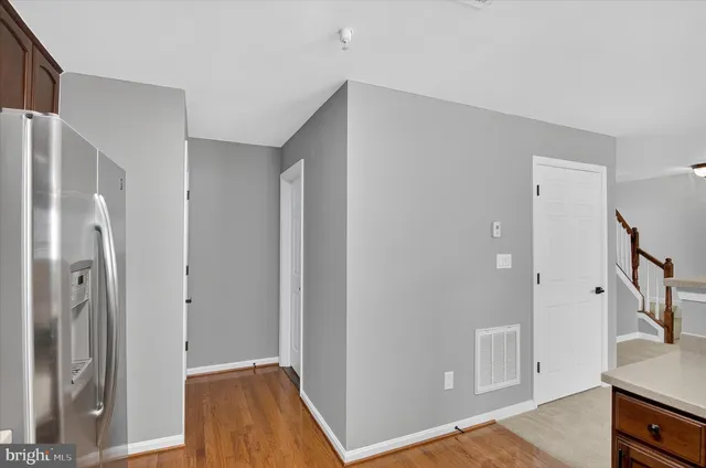 a view of kitchen with stainless steel appliances wooden cabinets and a refrigerator