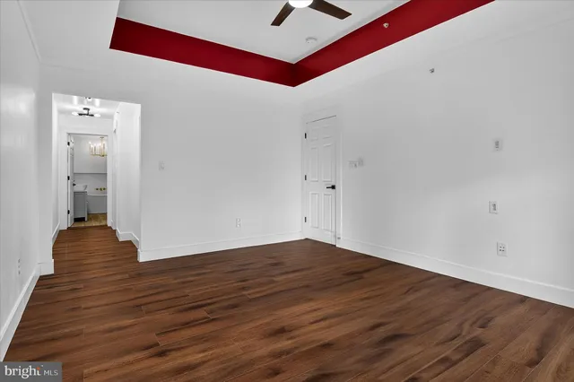 a view of an empty room with wooden floor and windows