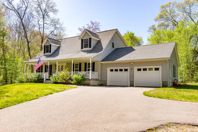 a front view of a house with a garden and yard