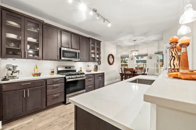 a kitchen with stainless steel appliances kitchen island granite countertop a sink and cabinets