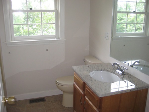 23 Stonegate Road Chelmsford, MA 01824 - Photo 8 of 15 a bathroom with a granite countertop sink a toilet and a window