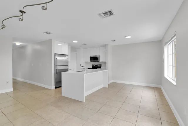 a kitchen with stainless steel appliances kitchen island sink refrigerator and microwave