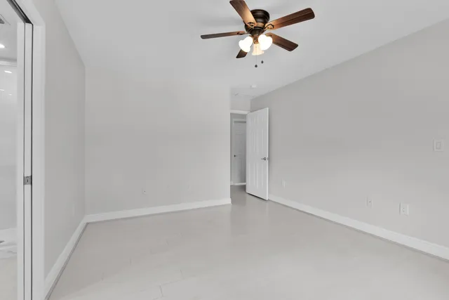 an empty room with a fan and a ceiling fan
