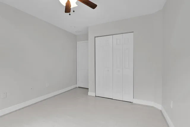 an empty room with chandelier fan