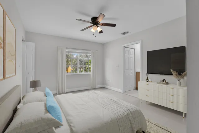 a bedroom with a bed and a flat tv screen on dresser