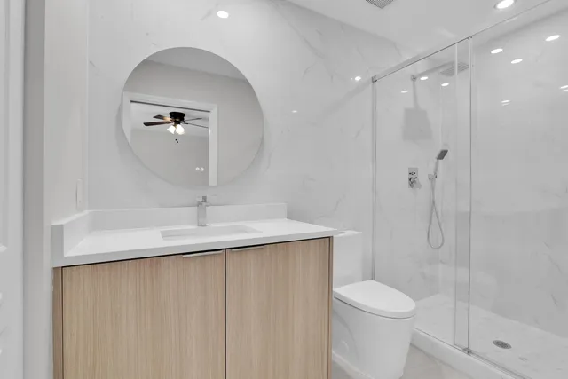 a bathroom with a sink a toilet and shower