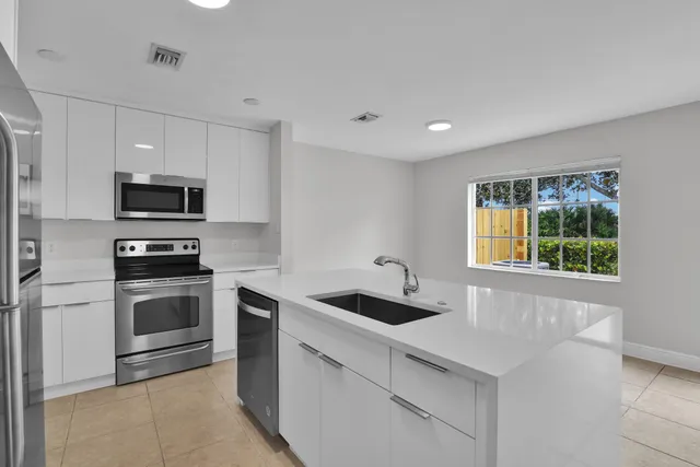 a kitchen with stainless steel appliances granite countertop a sink and a microwave