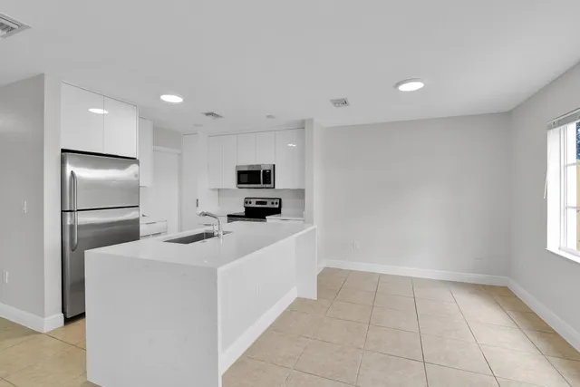 a kitchen with stainless steel appliances a refrigerator sink and microwave