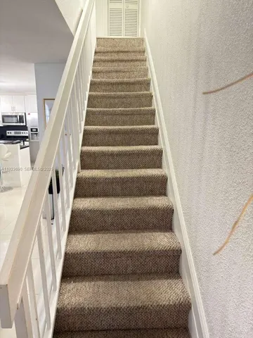 a view of staircase with lots of frames on wall