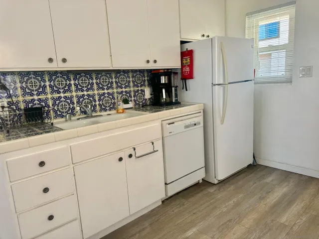 a kitchen with white cabinets and white appliances
