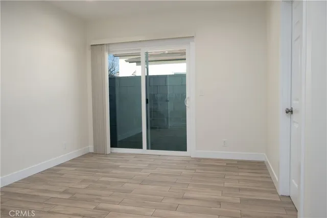 an empty room with wooden floor and a bathroom