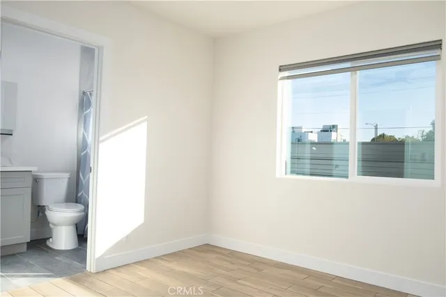 an empty room with wooden floor & closet area