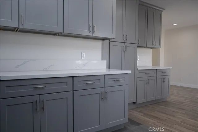 a kitchen with cabinets and wooden floor