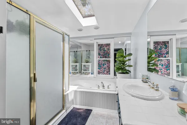 a bathroom with a sink and a bathtub next to a window