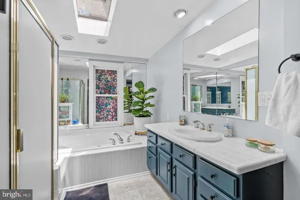 a bathroom with a tub sink and mirror