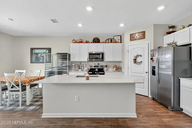 a kitchen with stainless steel appliances a refrigerator and a stove top oven