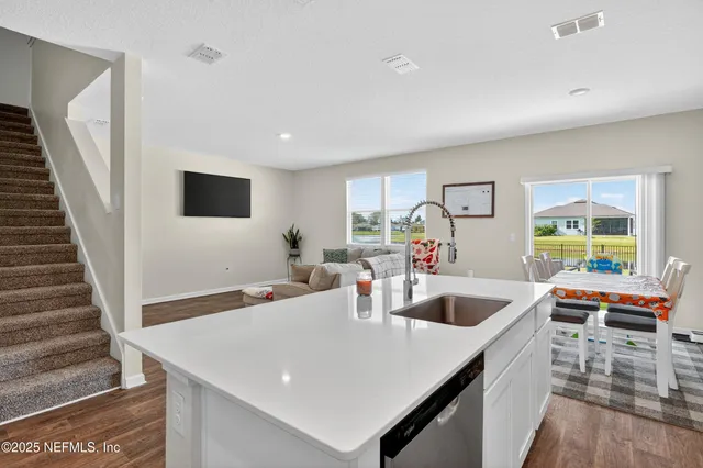 a kitchen with sink and view of living room