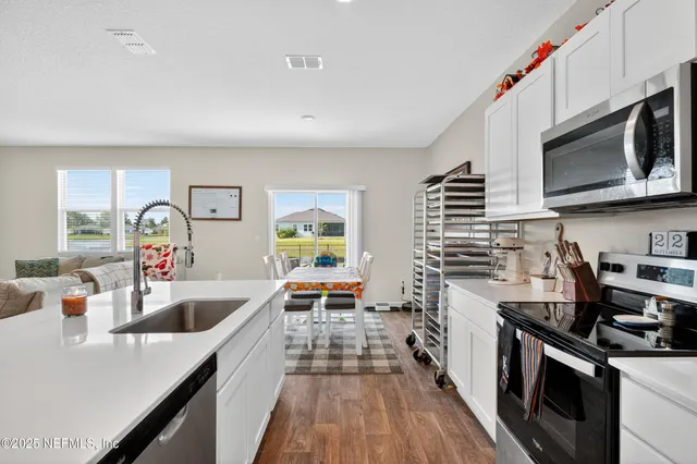 a kitchen with stainless steel appliances a stove a sink and a microwave