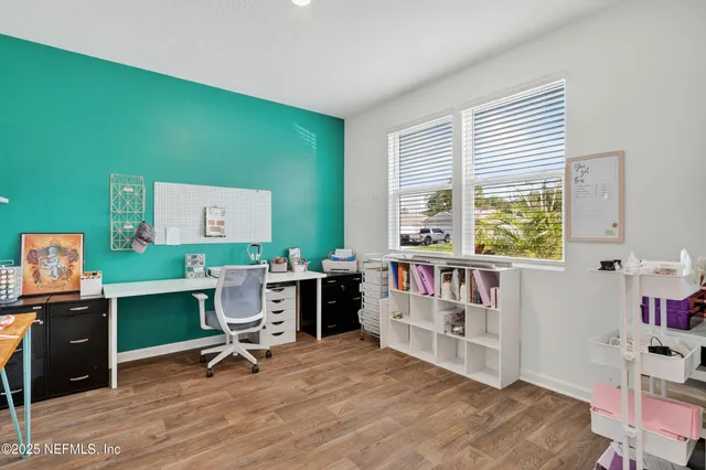 a view of a workspace with furniture and a window