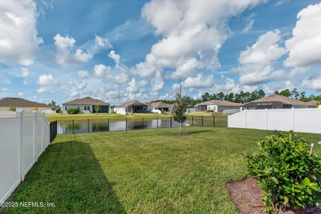 a view of a big house with a big yard and large trees