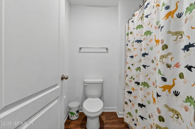 a bathroom with a toilet and a shower curtain