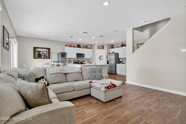 a living room with furniture and kitchen view