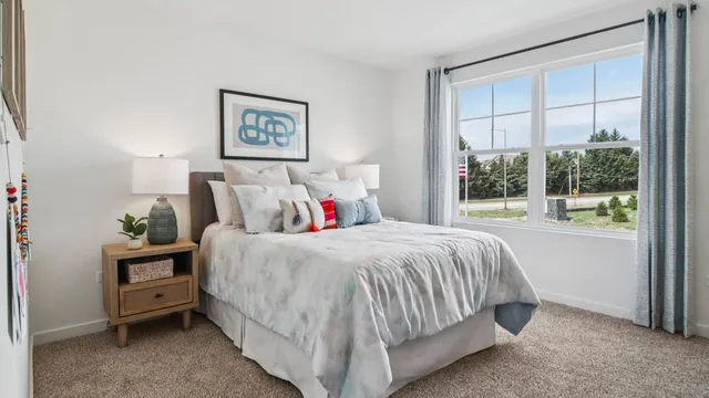 a bed sitting in a bedroom next to a window