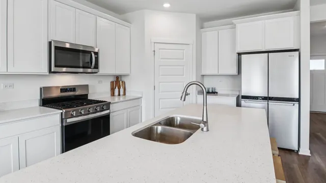 a kitchen with white cabinets and stainless steel appliances