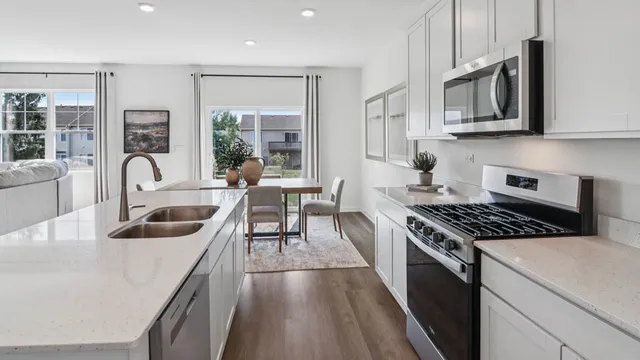 a kitchen with granite countertop stainless steel appliances a stove a sink and a cabinets