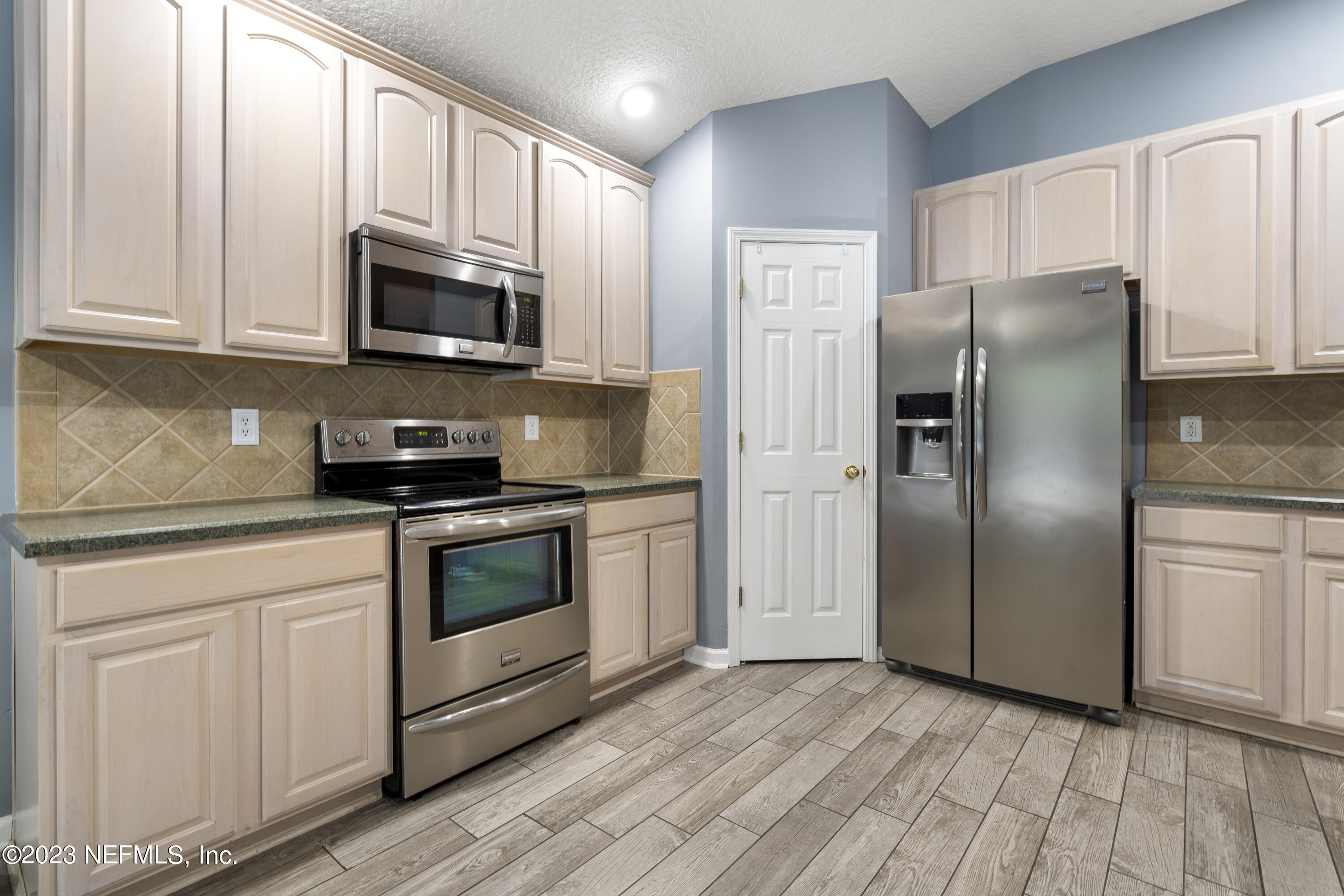 312 West Tropical Trace St. Johns, FL 32259 - Photo 19 of 57 a kitchen with stainless steel appliances granite countertop white cabinets a refrigerator and a stove
