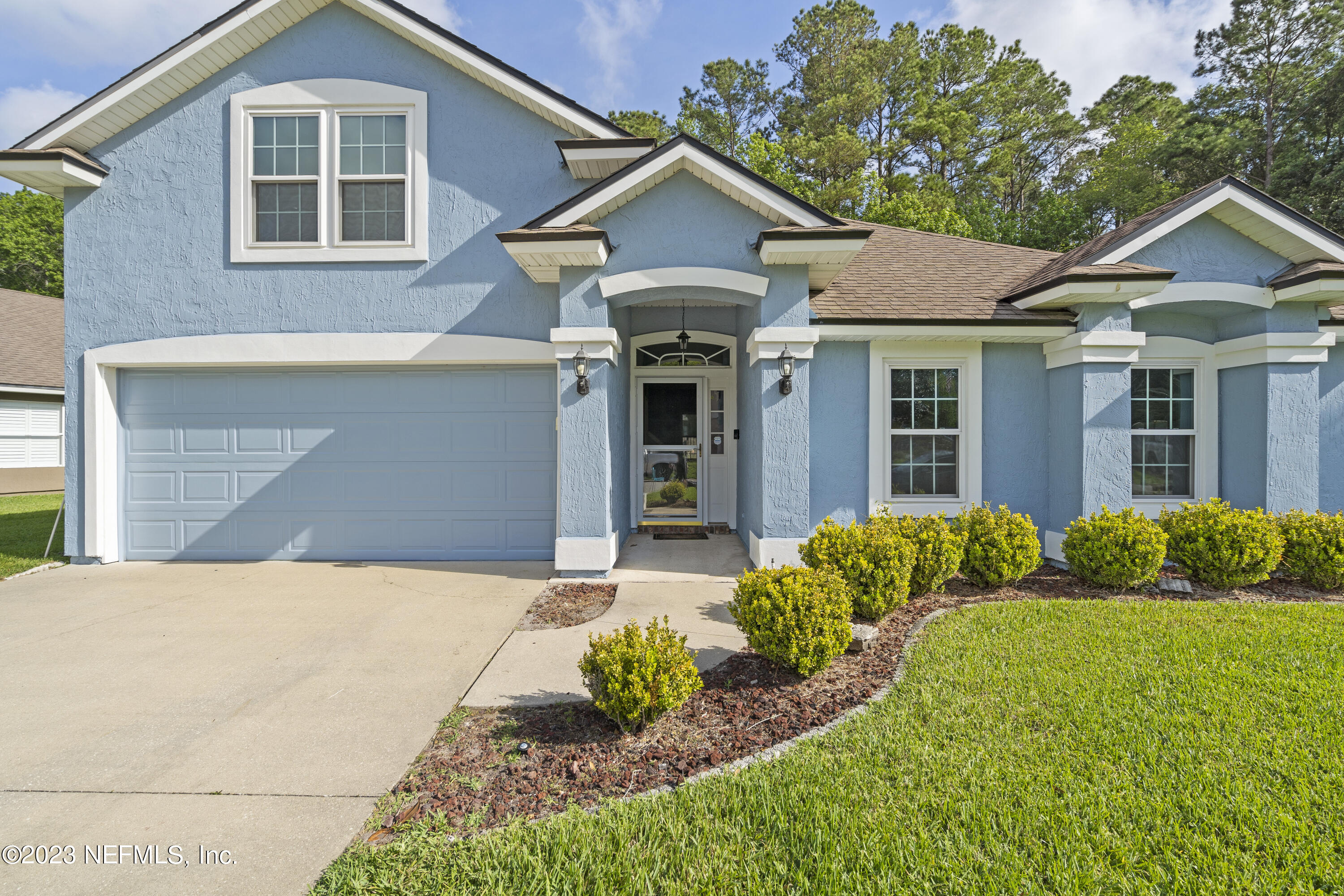 312 West Tropical Trace St. Johns, FL 32259 - Photo 2 of 57 a front view of a house with a yard and potted plants